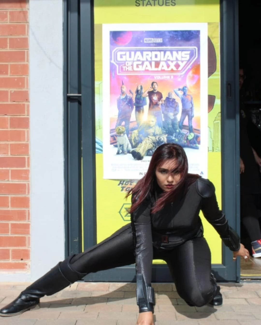 Lauren Maduray strikes a dynamic pose in black tactical gear, mirroring the fearless spirit of The Shadower, her comic book where real people become superheroes.