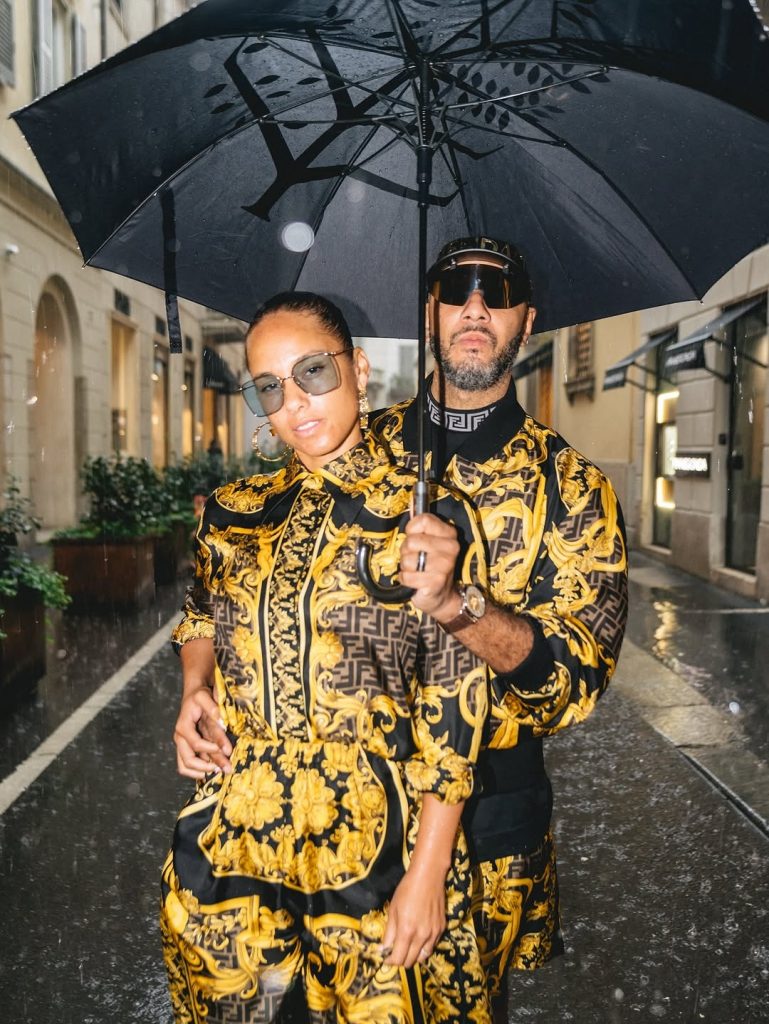Rain can’t dim their vibe! The fashionable duo steps out in matching outfits, with Swizz playing the perfect gentleman under the umbrella. Picture: Instagram@AliciaKeys