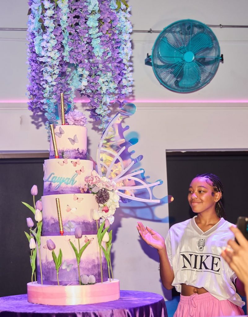 The star of the day: Monica’s daughter Laiyah beamed beside her beautiful four-tiered flower-adorned cake. Picture: Instagram@Monicadenise