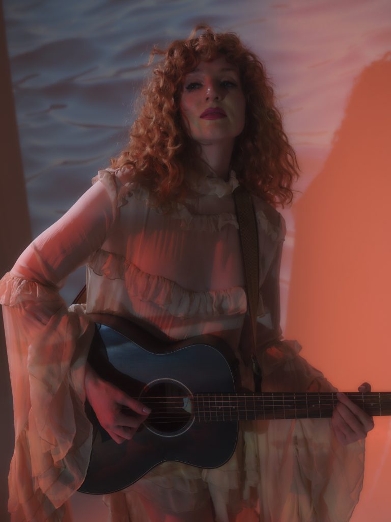 Lu_Ah cradles her guitar in a quiet, soulful moment. Picture: Supplied