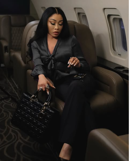 Khanyi Mbau exudes elegance in an all-black ensemble as she strikes a regal pose aboard a plane. Picture: Instagram@KhanyiMbau