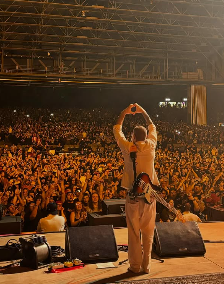 The late Sam Rivers captured in a powerful moment on stage, standing before the crowd, forming a heart with his hands. Picture: Instagram@SamRivers