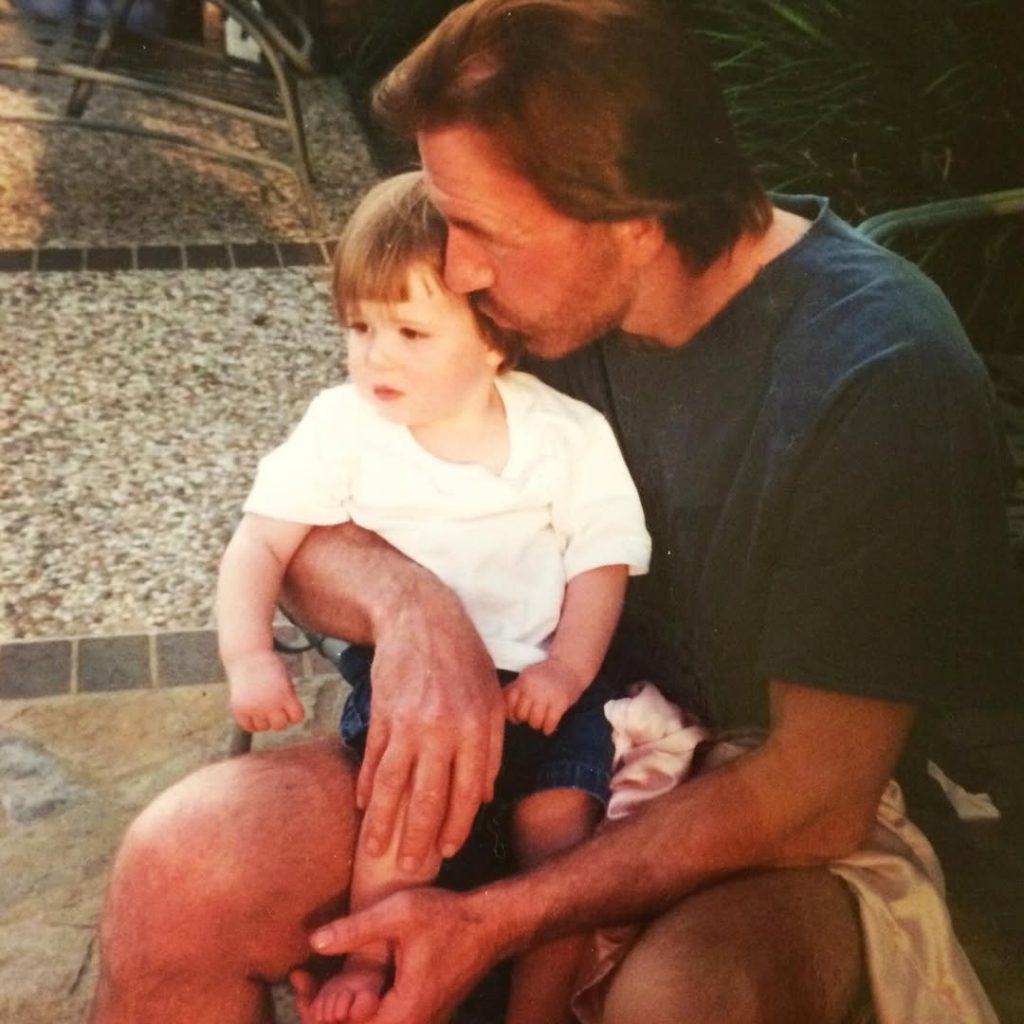 An old picture of the late Chuck Norris holding little Greta Norris tenderly in his arms. Picture: Instagram@GretaNorris