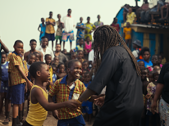 Hurricane Wisdom joyfully connecting with children in a scene from the “LIVING UP” video. Picture: Kevin “Cotto” Rivera