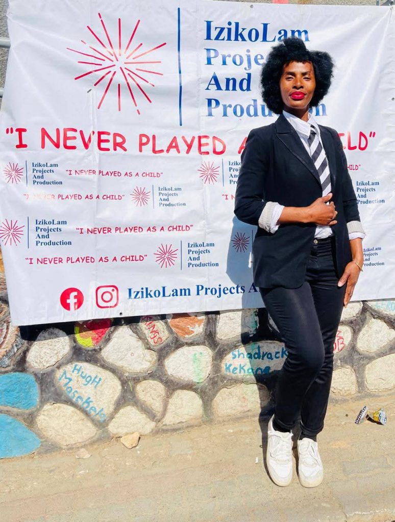 Nomveliso looking radiant as she poses in front of the “I Never Played As A Child” banner. Picture: Supplied