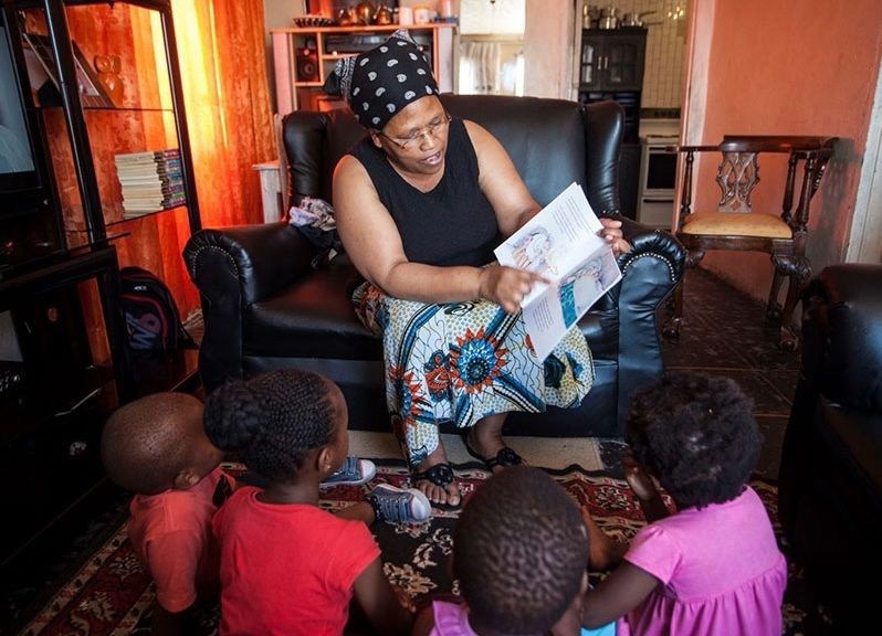 A mother spending quality time reading a storybook to her four little ones. Picture: Nal'ibali
