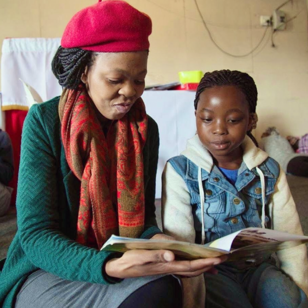 A parent reading a book with her child