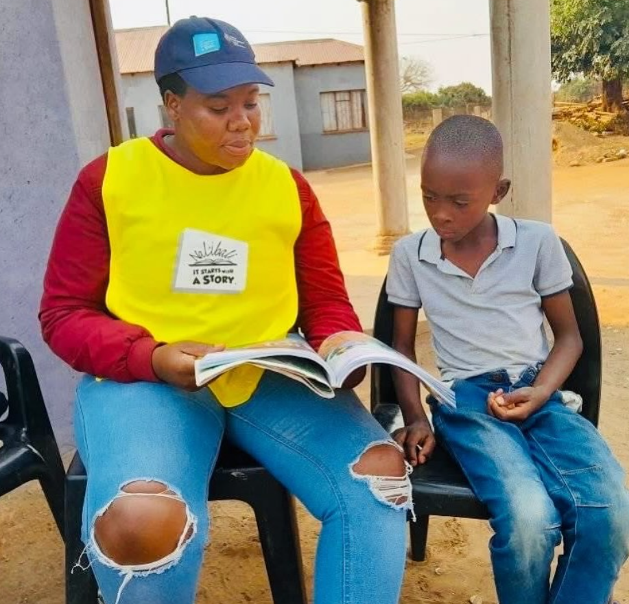 A Nal’ibali staff member reading a storybook to a young boy. Picture: Nal'ibali