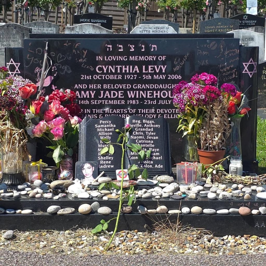 The late Amy Winehouse’s gravestone adorned with flowers and a photograph of her. Picture: Instagram@Thenatejames