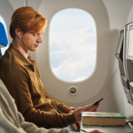 A passenger glances at his phone while boarding a KLM flight.